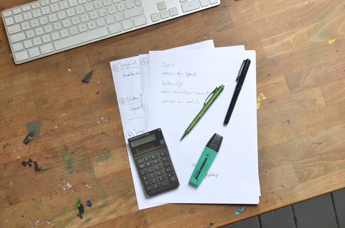Notizen, Taschenrechner und Unterlagen auf dem Schreibtisch — typische Fehlerquellen bei der Angebotskalkulation