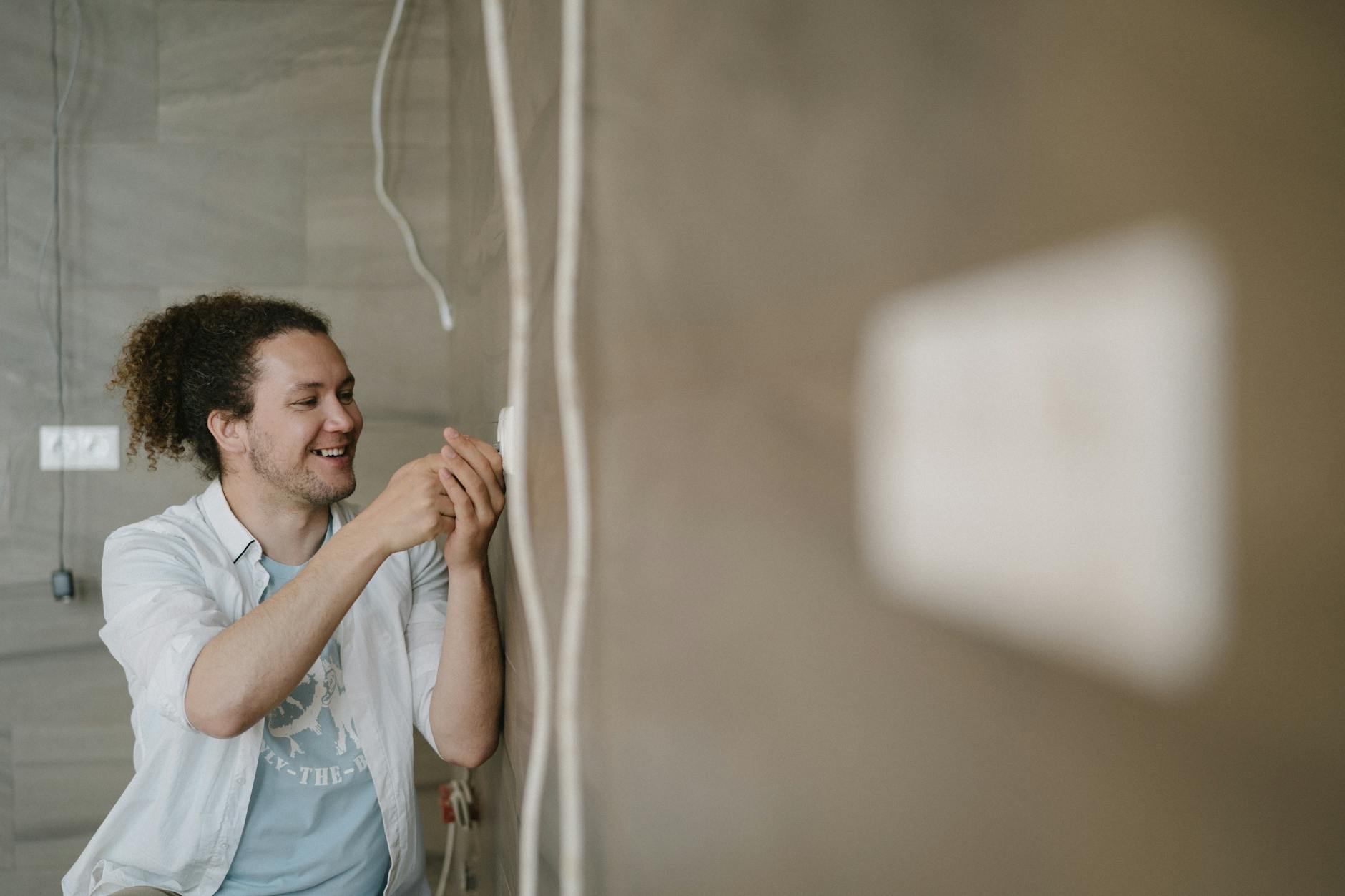 Elektriker arbeitet an einer Steckdose — Gewährleistungsfrist für Handwerker hängt von der Art der Installation ab