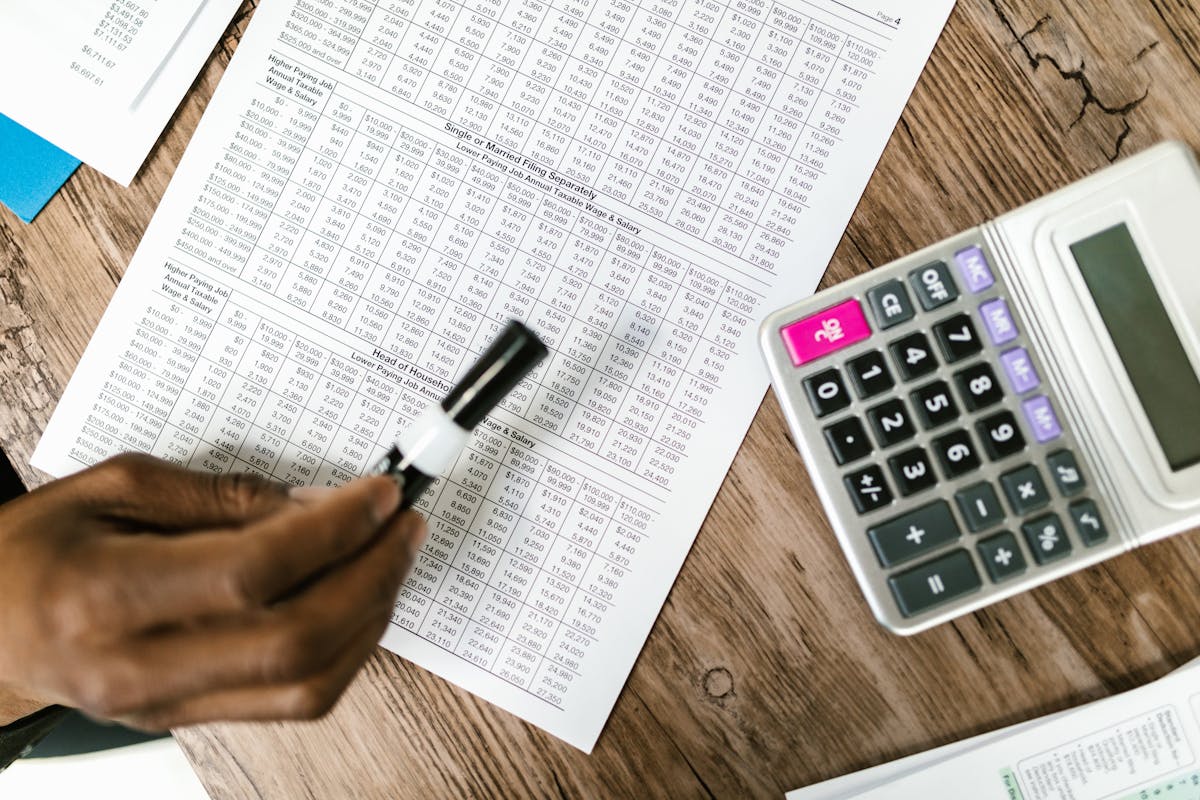Finanzdokument mit Taschenrechner auf dem Schreibtisch — Schlussrechnung prüfen
